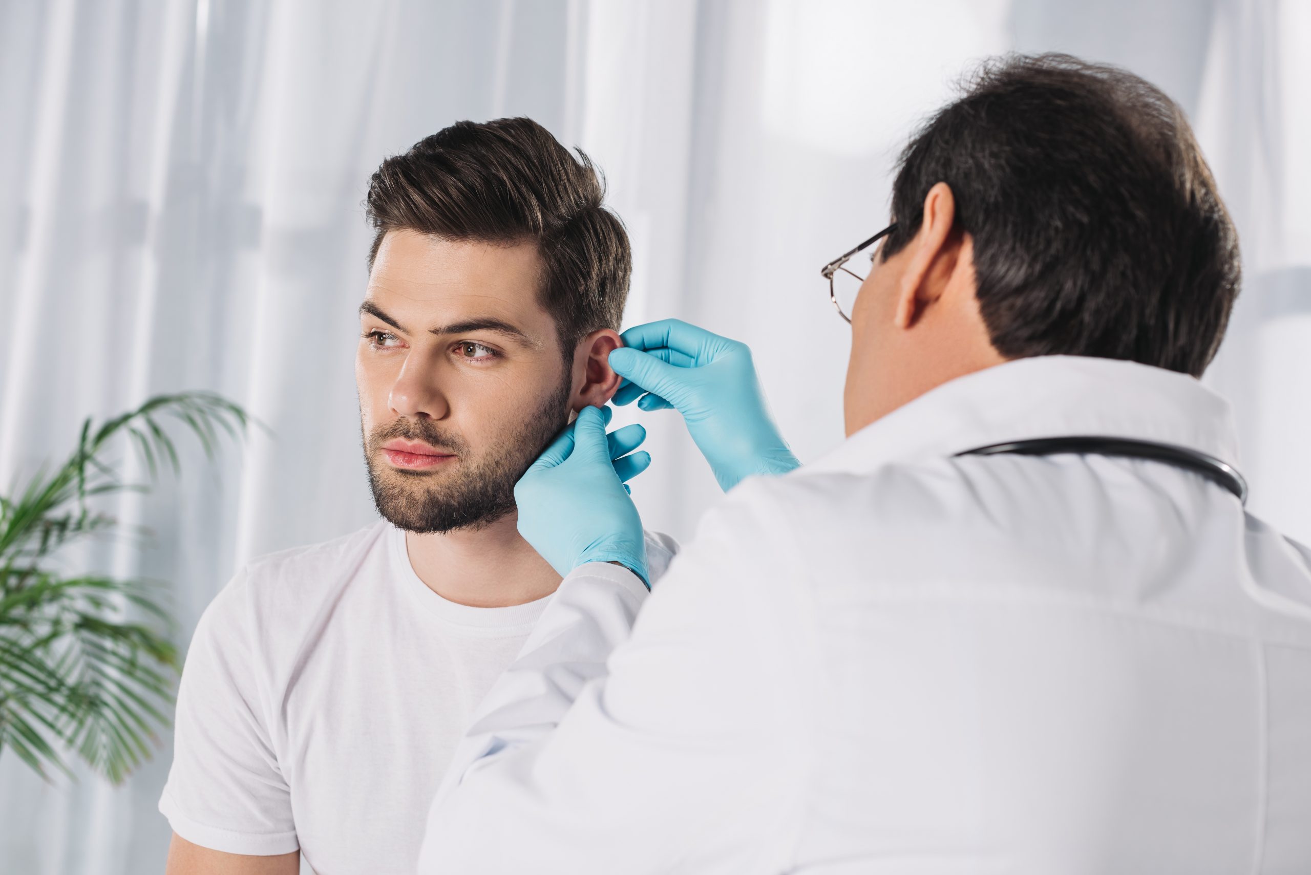 doctor examining male patient ear 2021 08 29 19 39 12 utc scaled - Otoplasty